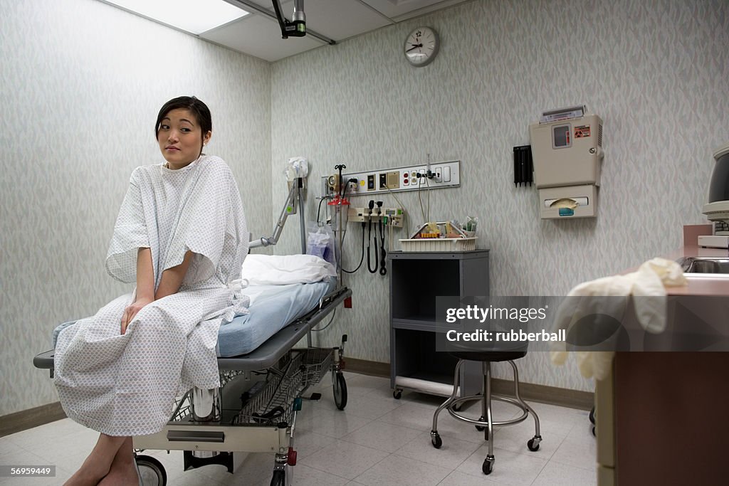 Low angle view of a young woman sitting on an examination table