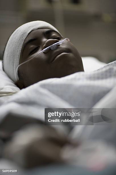 close-up of a teenage boy lying in a hospital bed - executivo chefe de operações - fotografias e filmes do acervo