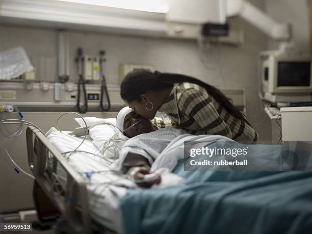 close-up of a mother kissing her son - unconscious - fotografias e filmes do acervo