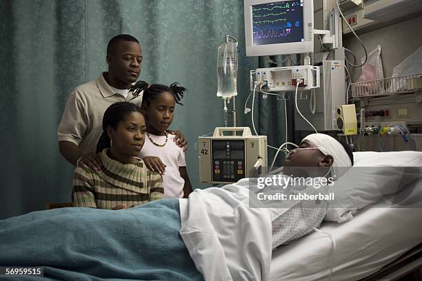 parents and their daughter looking at a teenage boy in the hospital - father confident secure reliable leader stock pictures, royalty-free photos & images