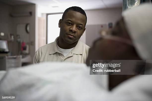 father sitting beside his son lying on a hospital bed - father confident secure reliable leader stock pictures, royalty-free photos & images