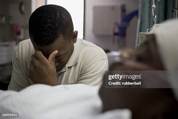 father sitting beside his son lying on a hospital bed - father confident secure reliable leader stock pictures, royalty-free photos & images