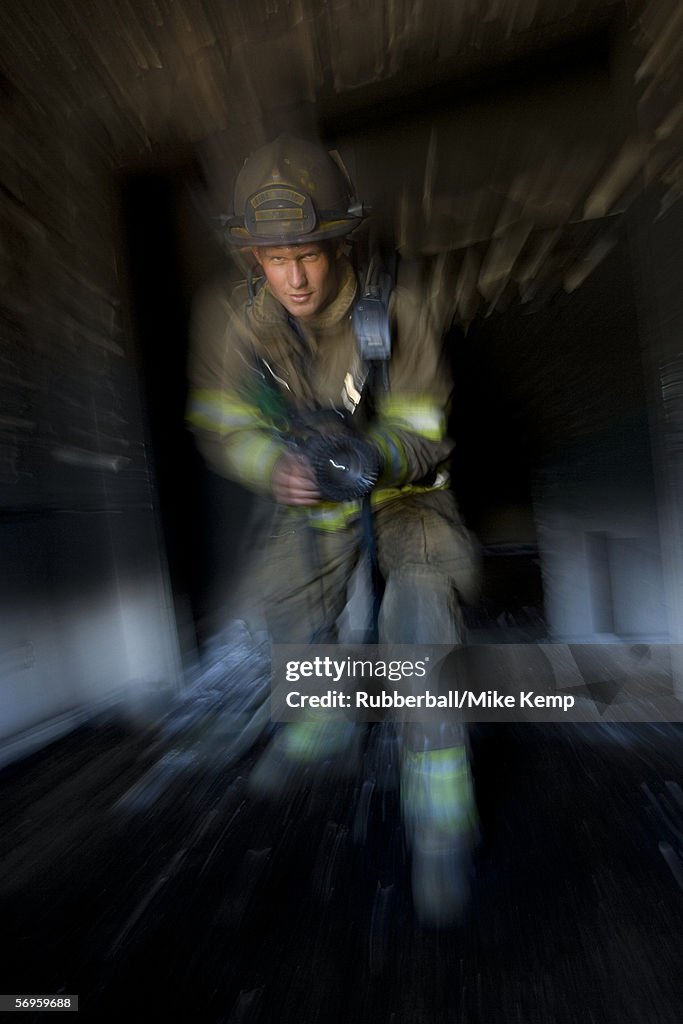 Portrait of a firefighter holding a fire hose