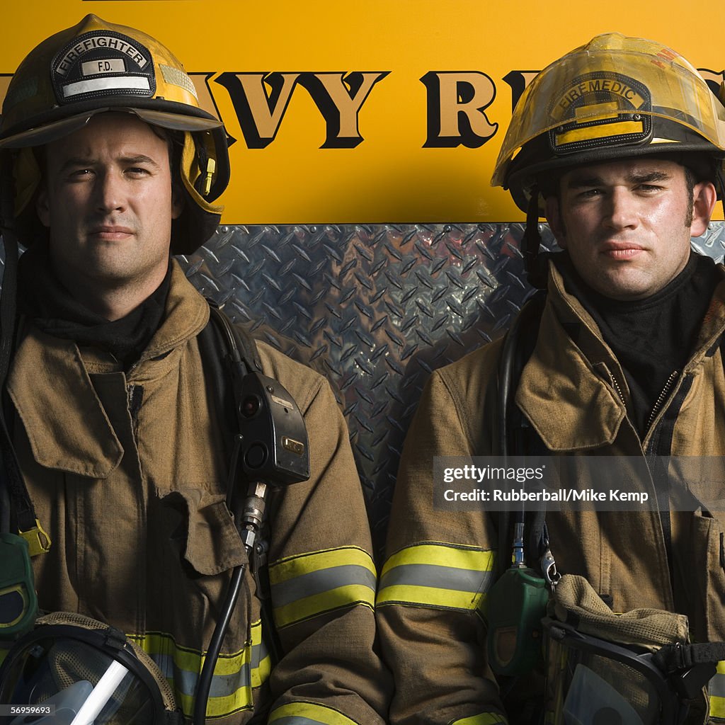 Portrait of two firefighters sitting