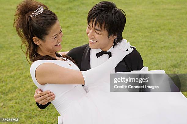 groom carrying bride - carrying bride stock pictures, royalty-free photos & images