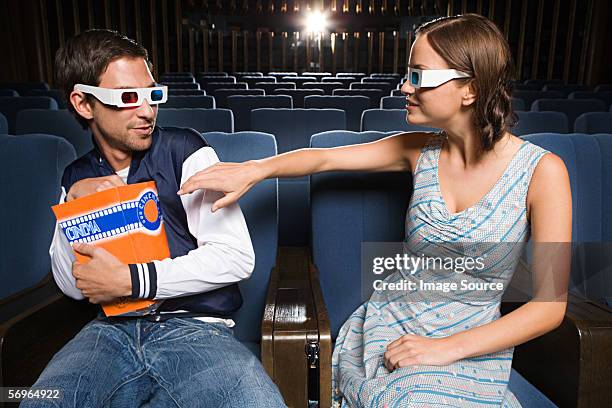 man being selfish with popcorn - couple in cinema seats stock pictures, royalty-free photos & images