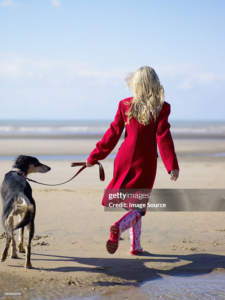 Woman walking her dog on the beach