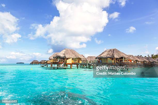 overwater bungalows in the lagoon of bora bora - french polynesia stockfoto's en -beelden