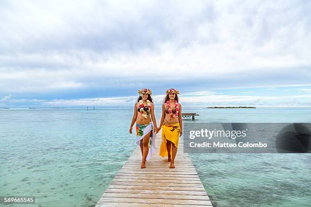 two polynesian girls walking on jetty, moorea - sarong stock-fotos und bilder