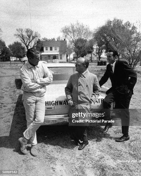 American novelist, short story writer, and playwright Truman Capote leans against the truck of a highway patrol police car and talks to an...