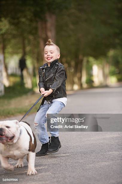 boy with mohawk in leather jacket walking dog - sleep walking stockfoto's en -beelden