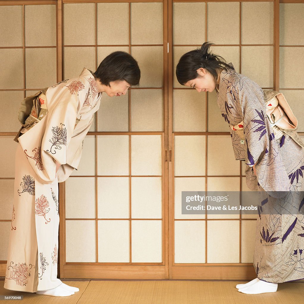 Two Asian women bowing