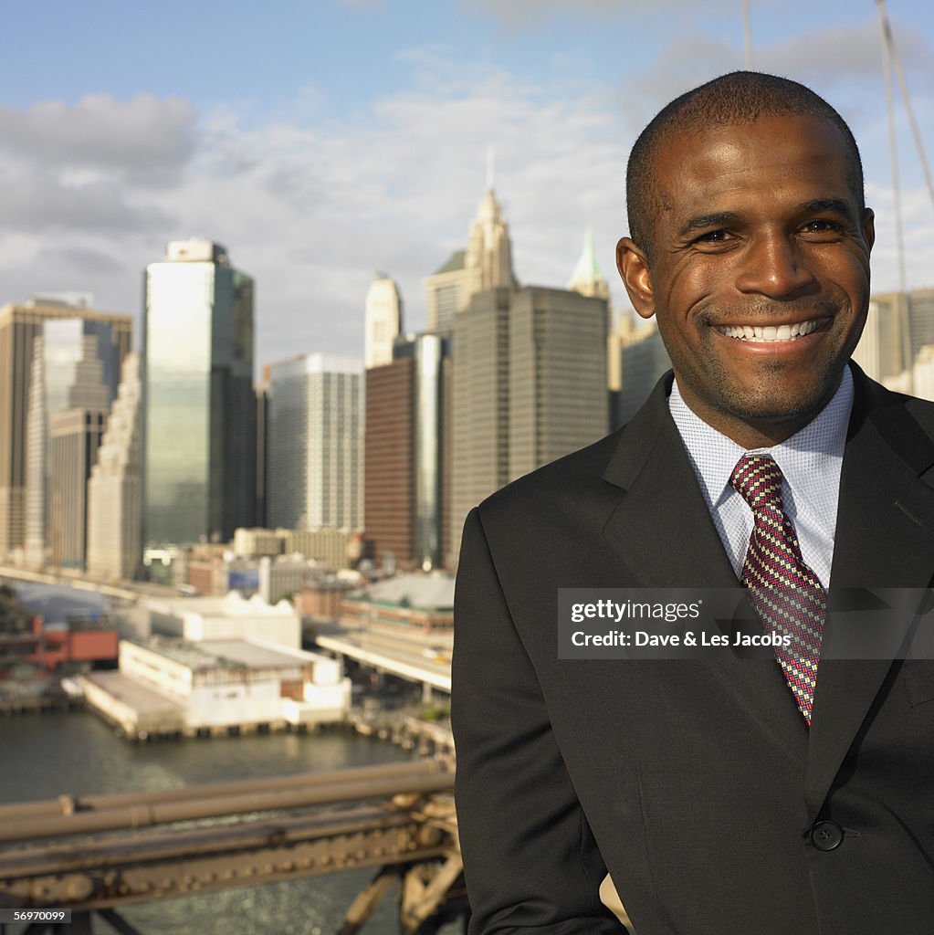 Businessman smiling with cityscape behind him