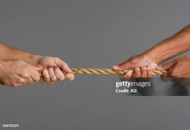 close up of tug-o-war with four hands - man pulling object fotografías e imágenes de stock