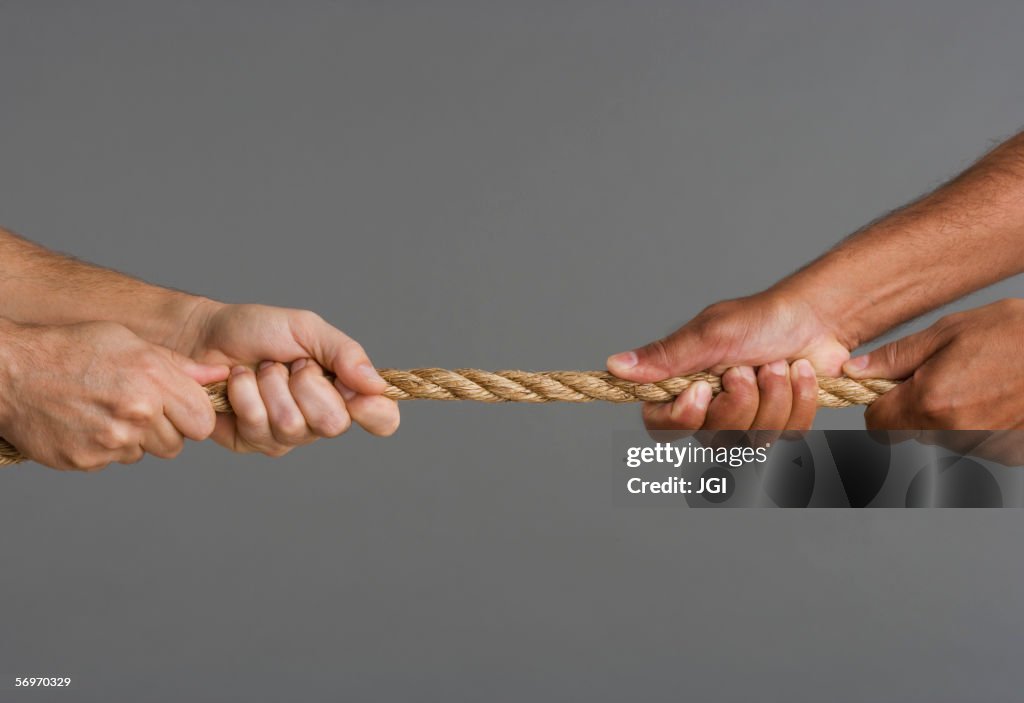 Close up of tug-o-war with four hands