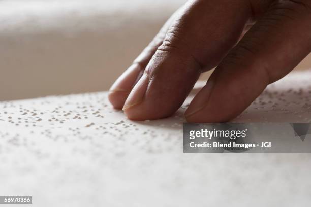 close up of hand reading braille - blindness stock-fotos und bilder