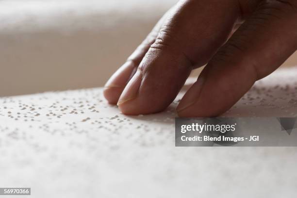 close up of hand reading braille - ciego fotografías e imágenes de stock