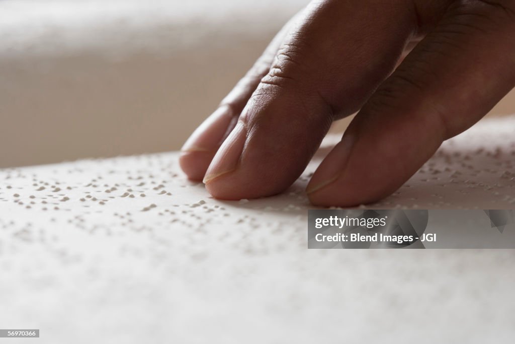 Close up of hand reading Braille