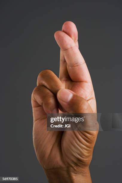 close up of hand with fingers crossed - blessing foto e immagini stock