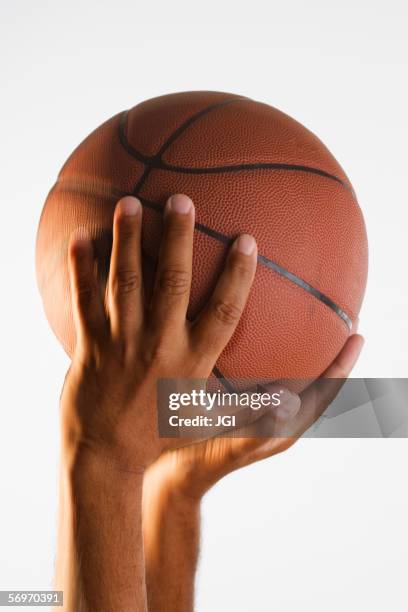 close up of hand holding basketball in air - basketball close up stock-fotos und bilder