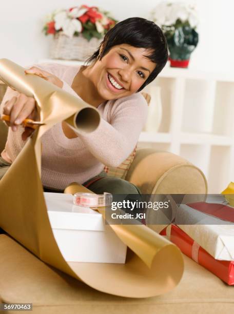 portrait of woman wrapping gifts - tape dispenser stock-fotos und bilder