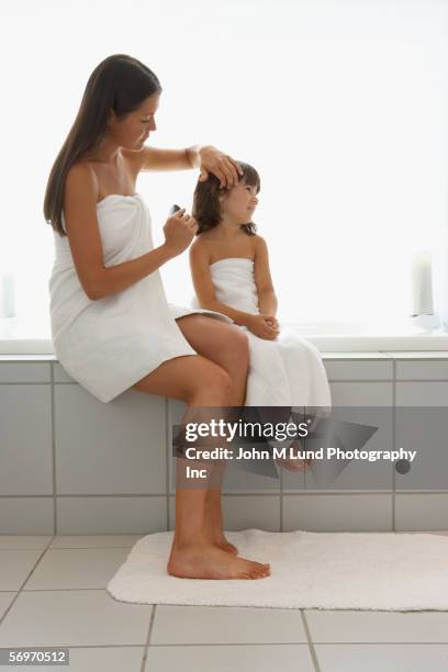 mother and daughter wrapped in towels brushing hair - enrolado em toalha de banho imagens e fotografias de stock
