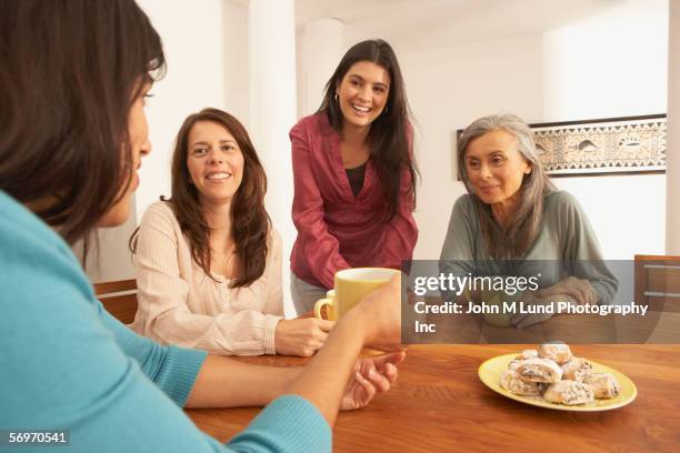 group of women sitting around table drinking coffee - kaffeeklatsch stock-fotos und bilder