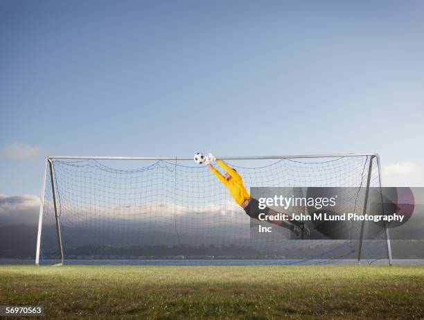 soccer goalie jumping for ball - goalkeeper soccer stockfoto's en -beelden