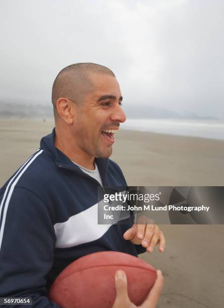profile of man holding football and laughing - waist up imagens e fotografias de stock