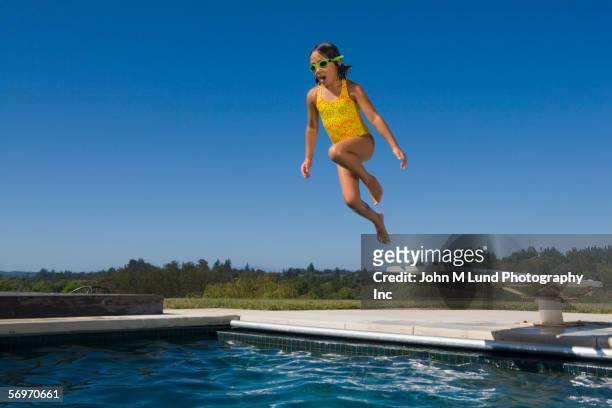 girl jumping off diving board into pool - young girls swimming pool stock pictures, royalty-free photos & images