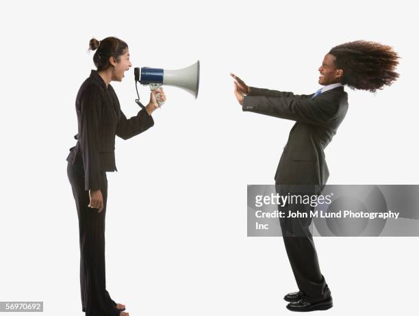 portrait of businesswoman screaming into megaphone at man - african american women in the wind stock pictures, royalty-free photos & images