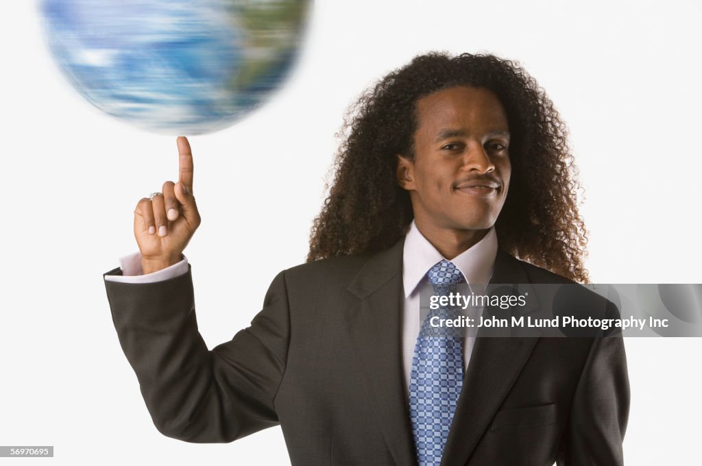 Portrait of businessman twirling globe