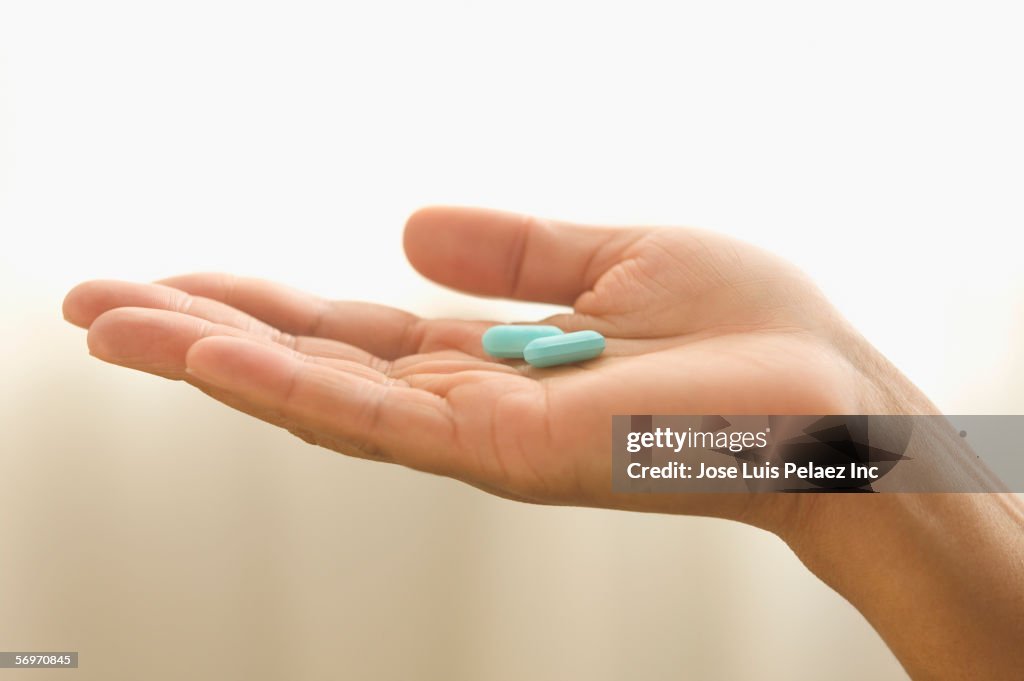Close up of hand holding pills