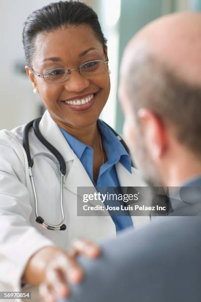 woman doctor smiling while talking to patient - cuban doctors stock-fotos und bilder