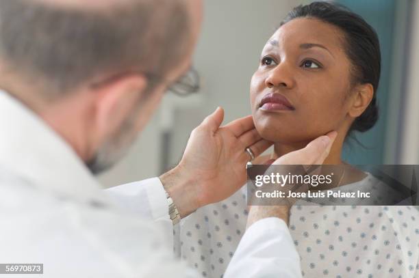 doctor examining glands of female patient - throat exam stock pictures, royalty-free photos & images
