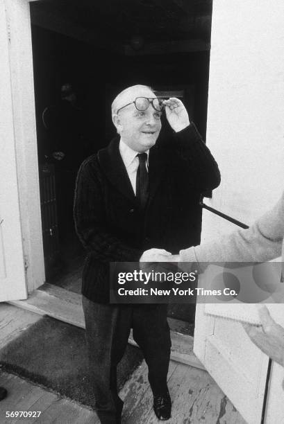 American novelist, short story writer, and playwright Truman Capote stands outside a doorway and shakes hands at the memorial service for American...