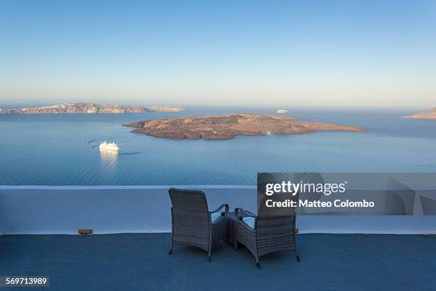 two empty chairs overlooking the sea at santorini - spartan cruiser stock pictures, royalty-free photos & images