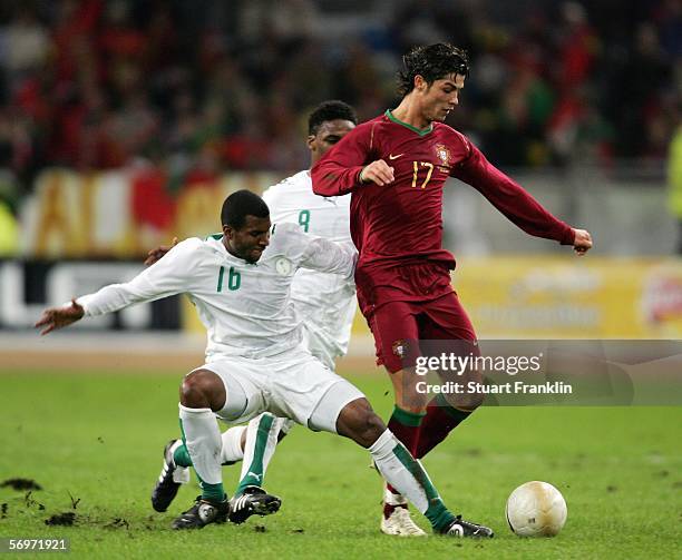 Cristiano Ronaldo of Portugal is challenged by Khaled Aziz A. Al Thaker and Mohammed Noor Hawsawi of Saudi Arabia during the international friendly...