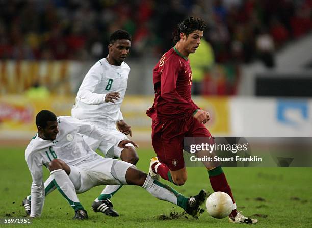 Cristiano Ronaldo of Portugal is challenged by Khaled Aziz A. Al Thaker and Mohammed Noor Hawsawi of Saudi Arabia during the international friendly...