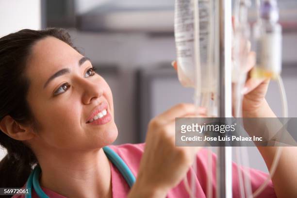 female nurse checking insulin - iv drip stock-fotos und bilder