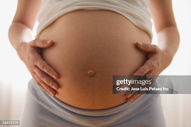 close up of pregnant woman's belly - embarazada fotografías e imágenes de stock