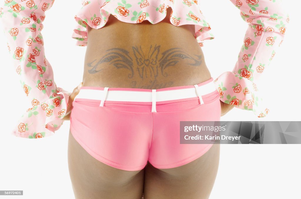 Rear mid section view of woman's back with tattoo