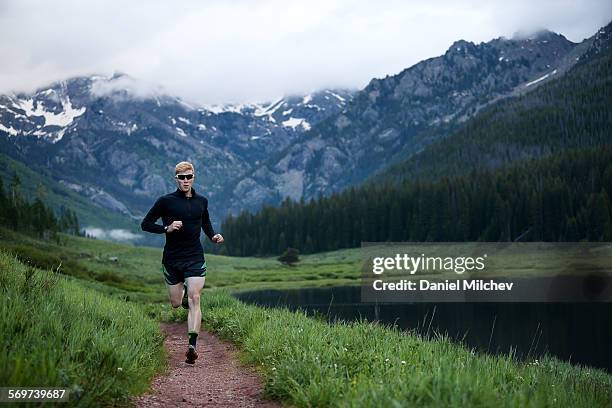 guy running during sunrise at a mountain lake. - vail colorado stock pictures, royalty-free photos & images