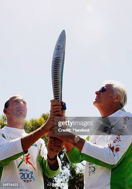Leigh Miller and John Blackmore hold the Melbourne 2006 Queen's Baton during its journey from Traralgon to Cowes as part of the Melbourne 2006...