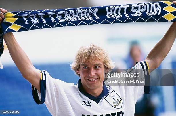 German footballer Jürgen Klinsmann holds up a Tottenham Hotspur scarf after signing with the club, 4th August 1994.