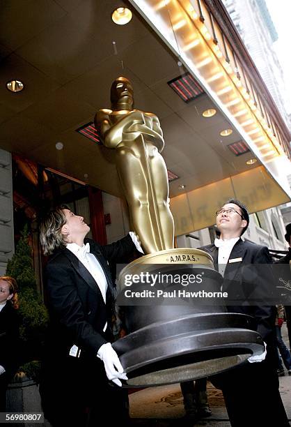 St Regis Hotel Butlers Tamara Nisonova and Wonhee deliver one of four, eight foot Oscar statues in preparation for the Academy of Motion Picture Arts...