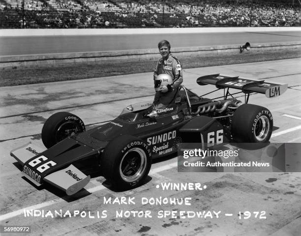 Portrait of American racing driver Mark Donohue as he poses with his car after winning the Indianapolis 500 race, Speedway, Indiana, May 1972.