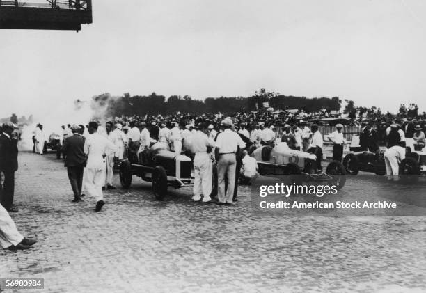 View of crews and drivers as they assemble to discuss last minute strategies on the brick-surfaced starting line for the Indianapolis 500 motor race,...