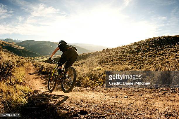 woman flying on a downhill mountain bike. - sportivo foto e immagini stock