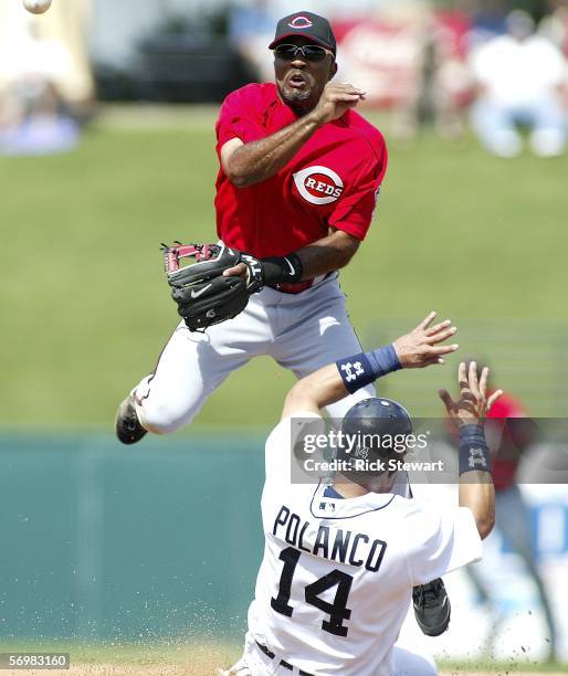 Second baseman Tony Womack of the Cincinnati Reds turns a double play as Placido Polanco of the Detroit Tigers slides into second base during a...